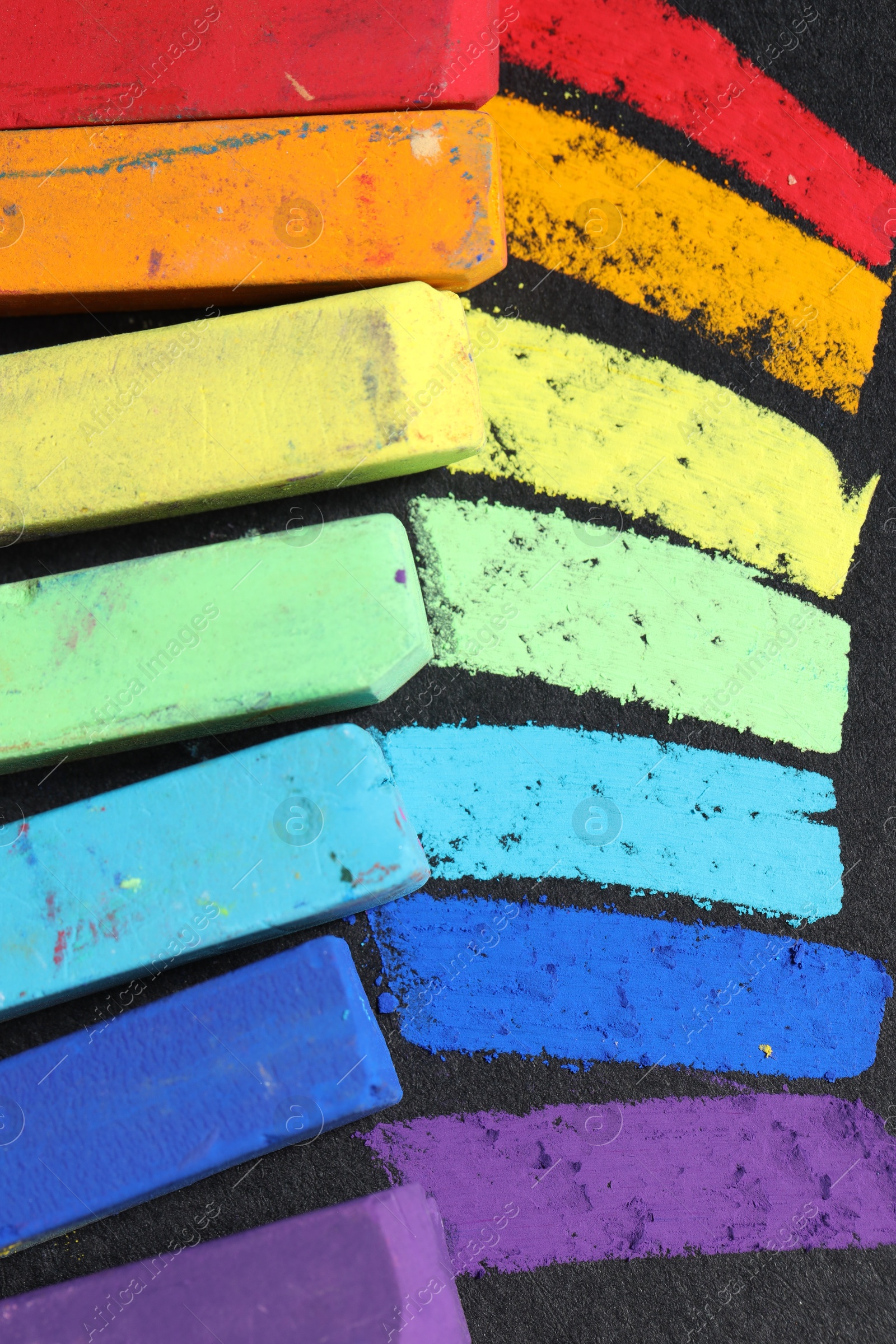 Colorful chalk pastels on black background, flat lay Photo of Colorful chalk pastels on black background, flat lay