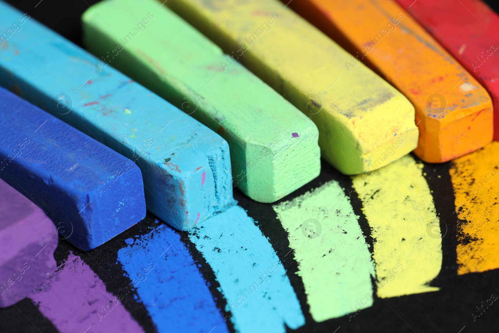Colorful chalk pastels on black background, closeup Photo of Colorful chalk pastels on black background, closeup