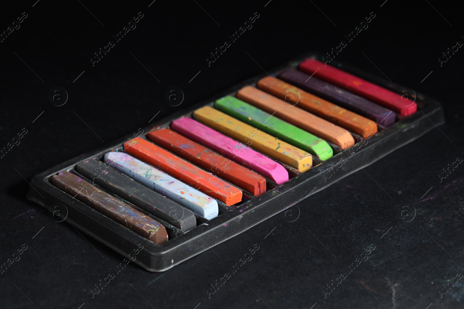 Photo of Set of colorful chalk pastels on black background