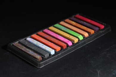 Photo of Set of colorful chalk pastels on black background