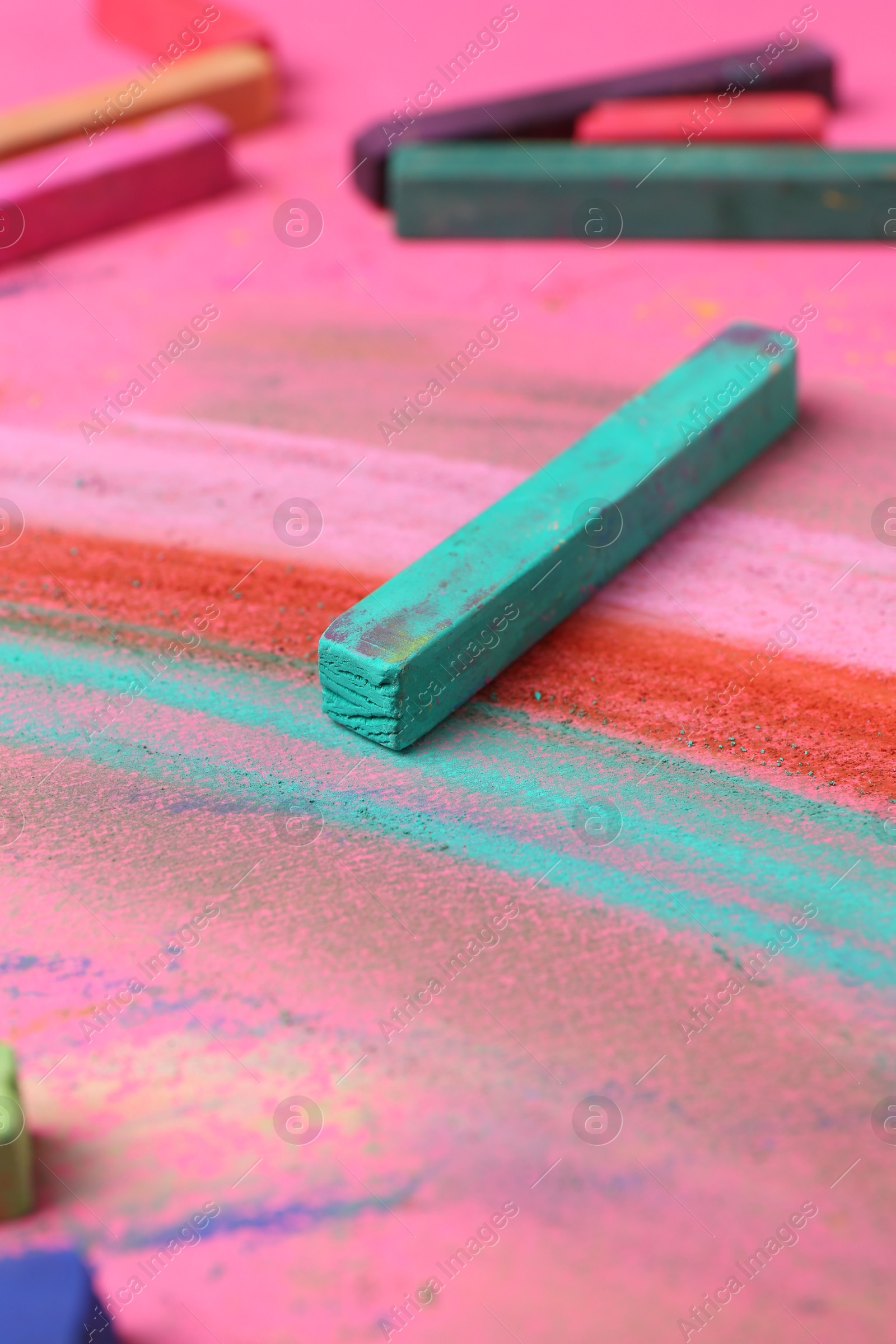Many colorful chalk pastels on pink background, closeup Photo of Many colorful chalk pastels on pink background, closeup