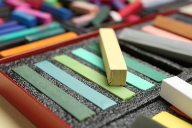 Photo of Set of colorful chalk pastels on beige background, closeup