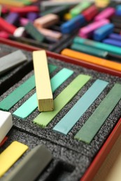 Photo of Set of colorful chalk pastels on beige background, closeup