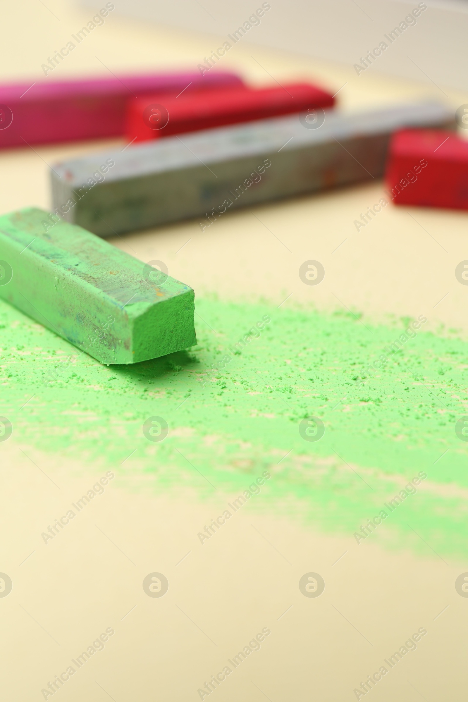 Photo of Many colorful chalk pastels on beige background, closeup