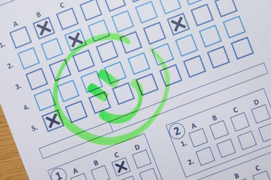 Photo of Happy face drawn on answer sheet, top view. Student passing exam
