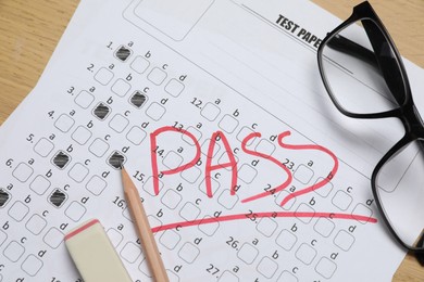 Photo of Answer sheet with word Pass, eraser, pencil and glasses on table, top view. Student passing exam