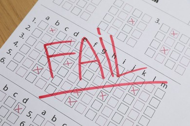 Photo of Answer sheet with word Fail on table, closeup. Student passing exam