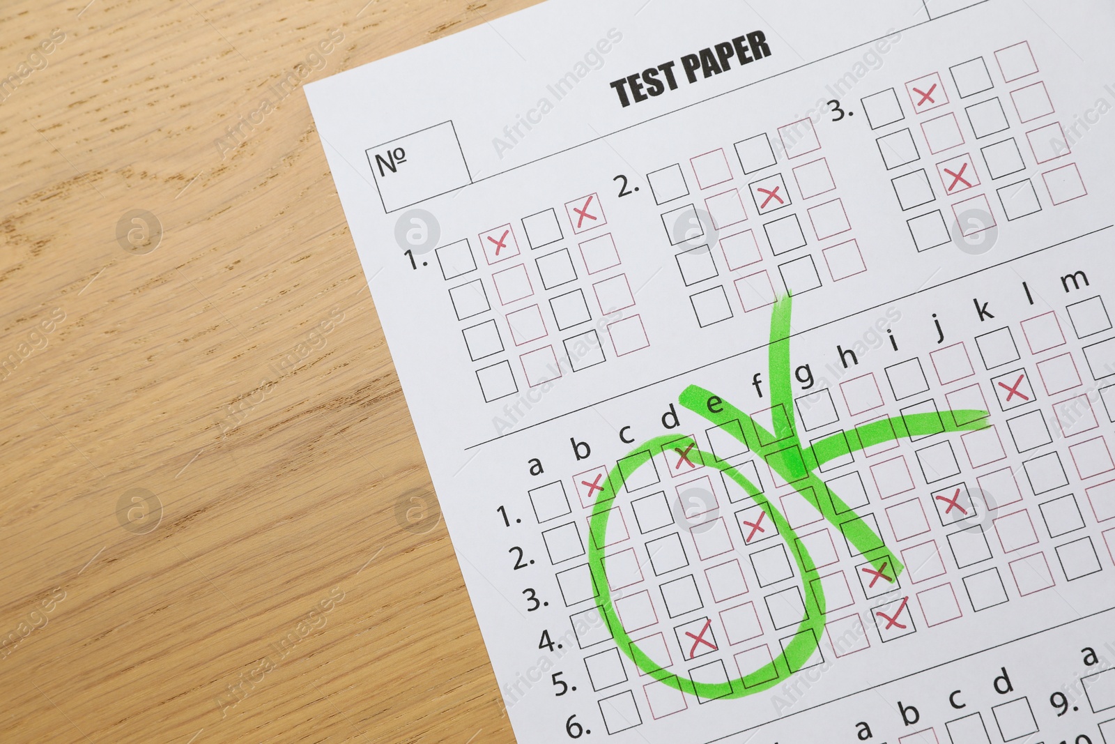 Photo of Answer sheet with word Ok on wooden table, top view. Student passing exam