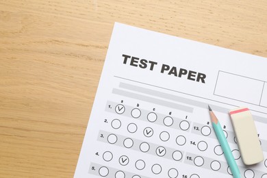 Photo of Answer sheet, eraser and pencil on wooden table, flat lay. Student passing exam
