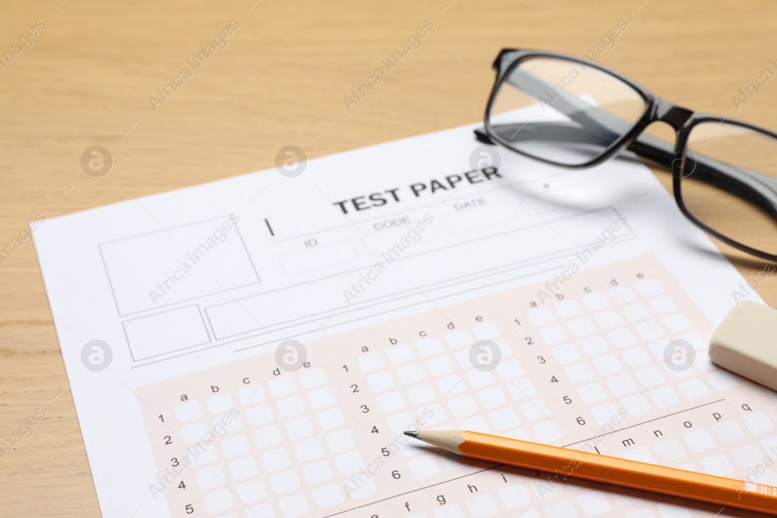 Answer sheet, eraser, pencil and glasses on wooden table, closeup. Student passing exam Photo of Answer sheet, eraser, pencil and glasses on wooden table, closeup. Student passing exam