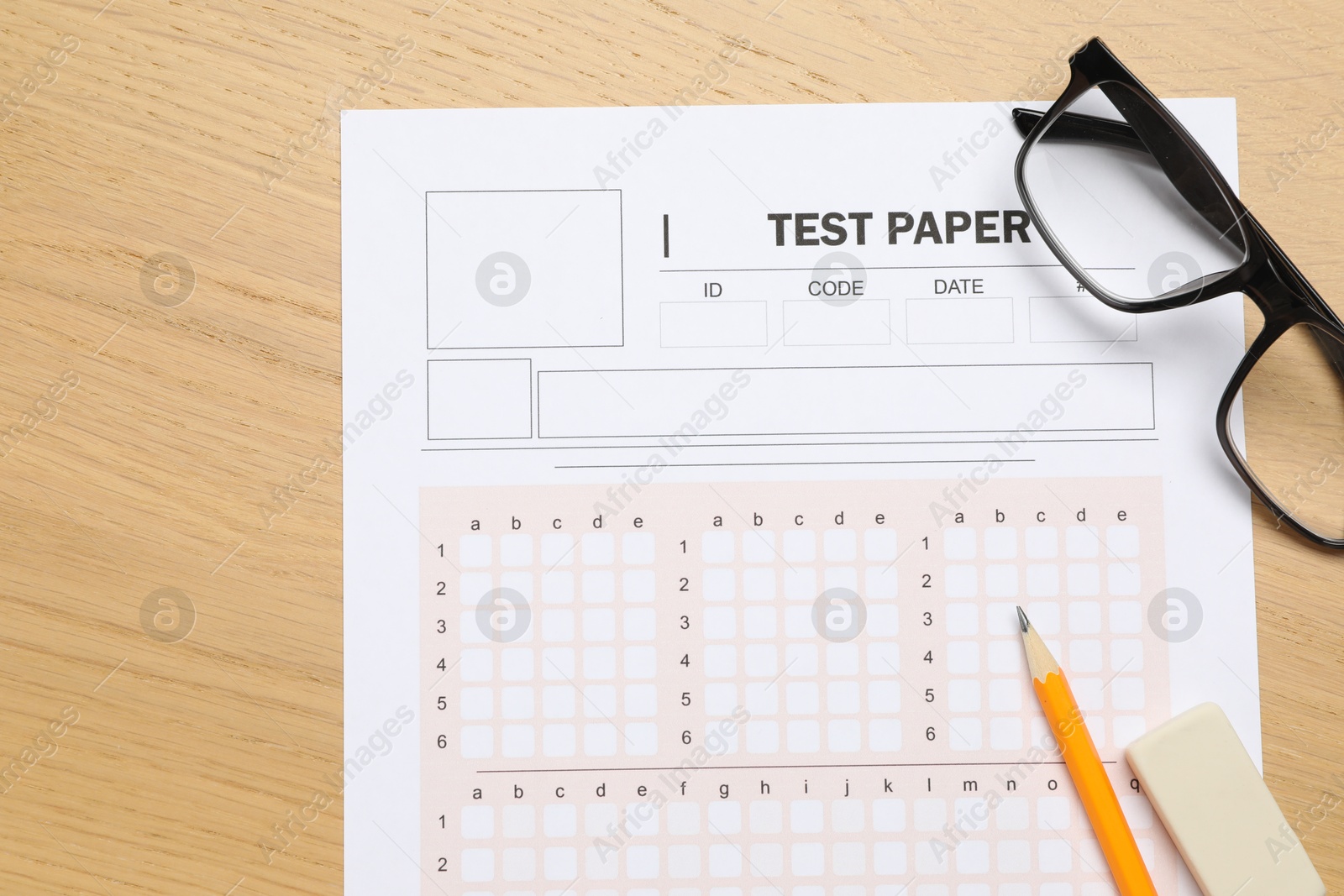 Answer sheet, eraser, pencil and glasses on wooden table, flat lay. Student passing exam Photo of Answer sheet, eraser, pencil and glasses on wooden table, flat lay. Student passing exam