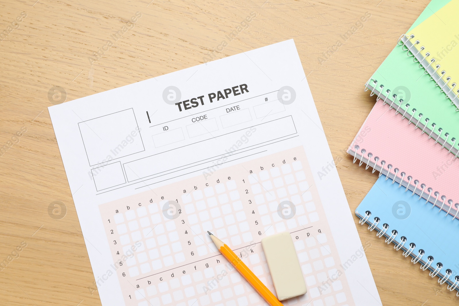 Photo of Answer sheet, eraser, pencil and notebooks on wooden table, flat lay. Student passing exam