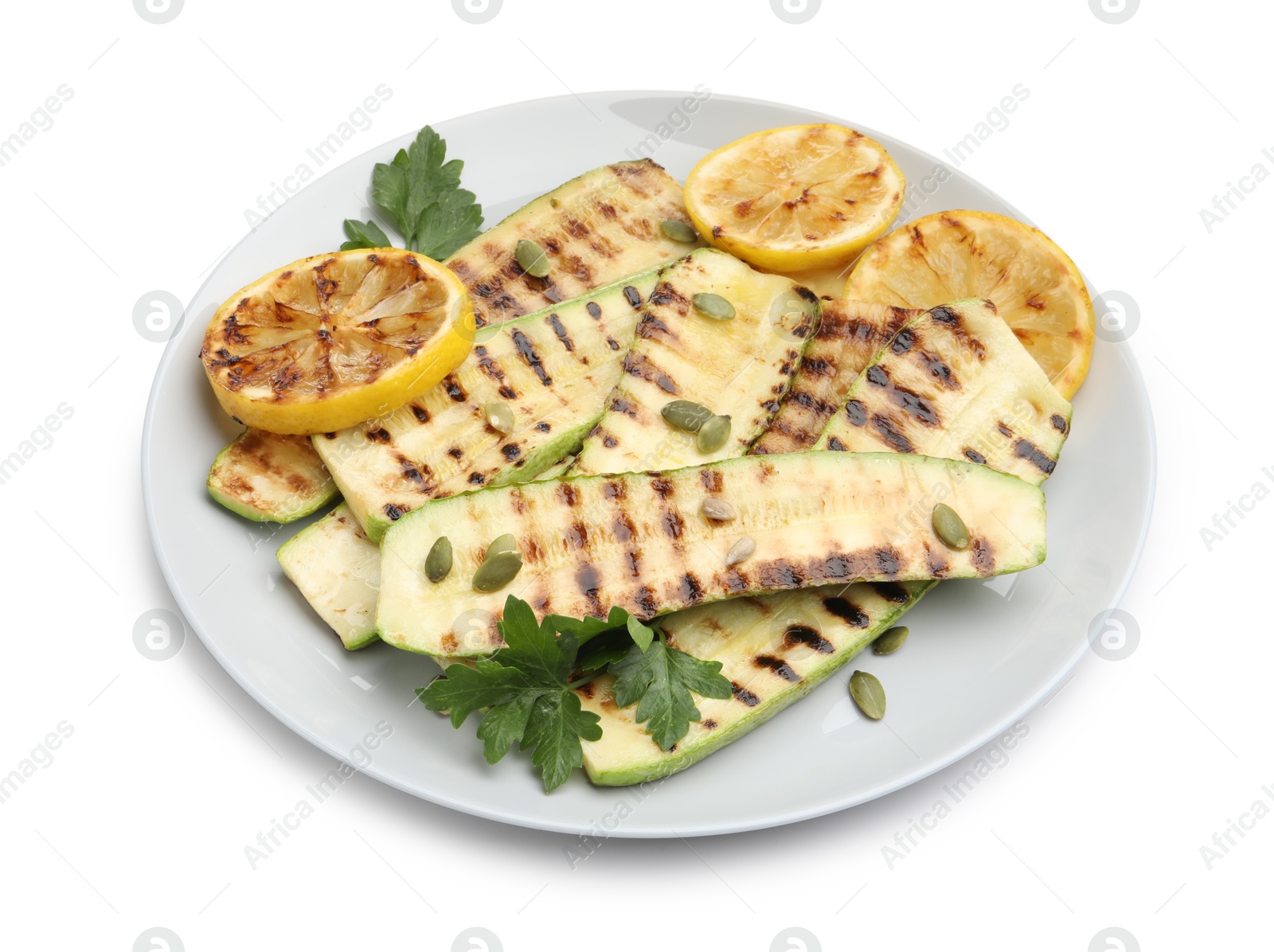 Photo of Delicious grilled courgette slices with pumpkin seeds, lemon and parsley isolated on white