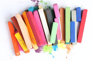Photo of Many colorful chalk pastels on white background, top view