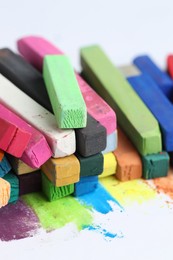 Photo of Many colorful chalk pastels on white background, closeup