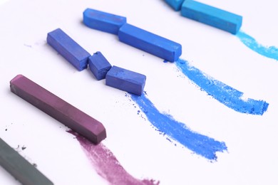Photo of Colorful chalk pastels on white background, closeup