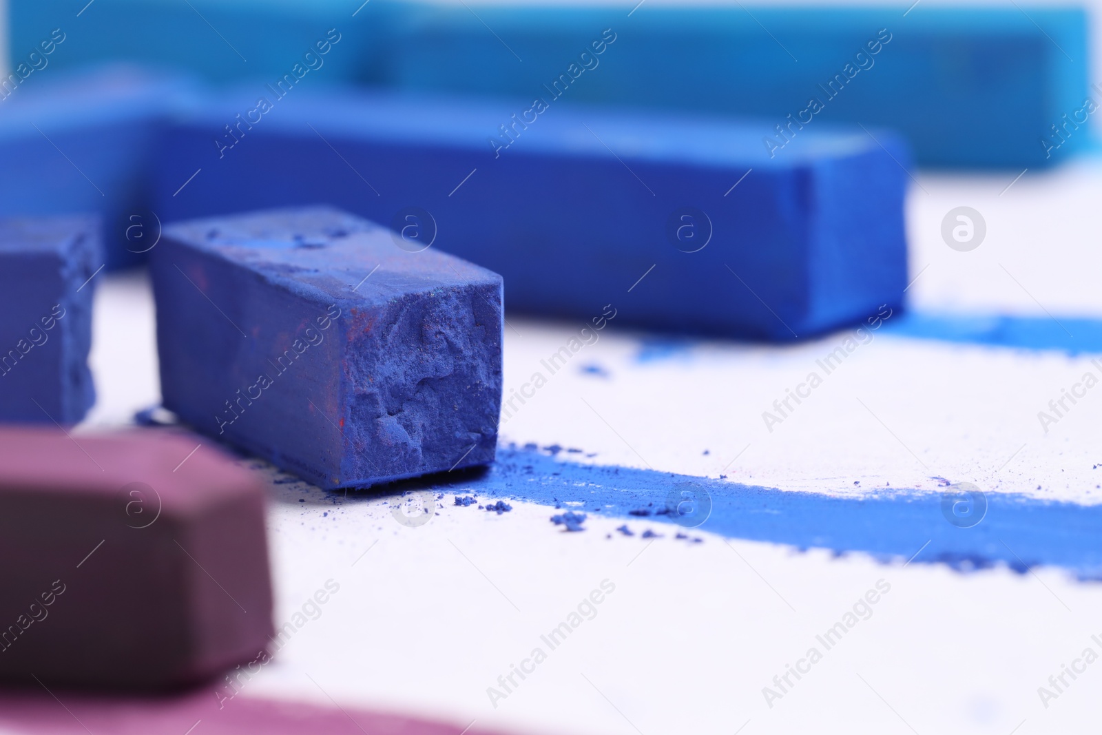 Photo of Colorful chalk pastels on white background, closeup