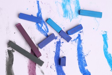 Photo of Colorful chalk pastels on white background, flat lay