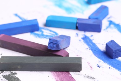 Photo of Colorful chalk pastels on white background, closeup