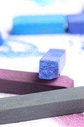 Photo of Colorful chalk pastels on white background, closeup