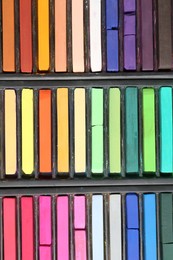 Photo of Set of colorful chalk pastels as background, closeup