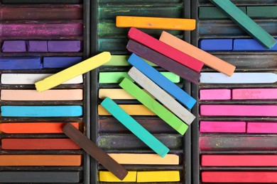 Photo of Set of colorful chalk pastels as background, closeup