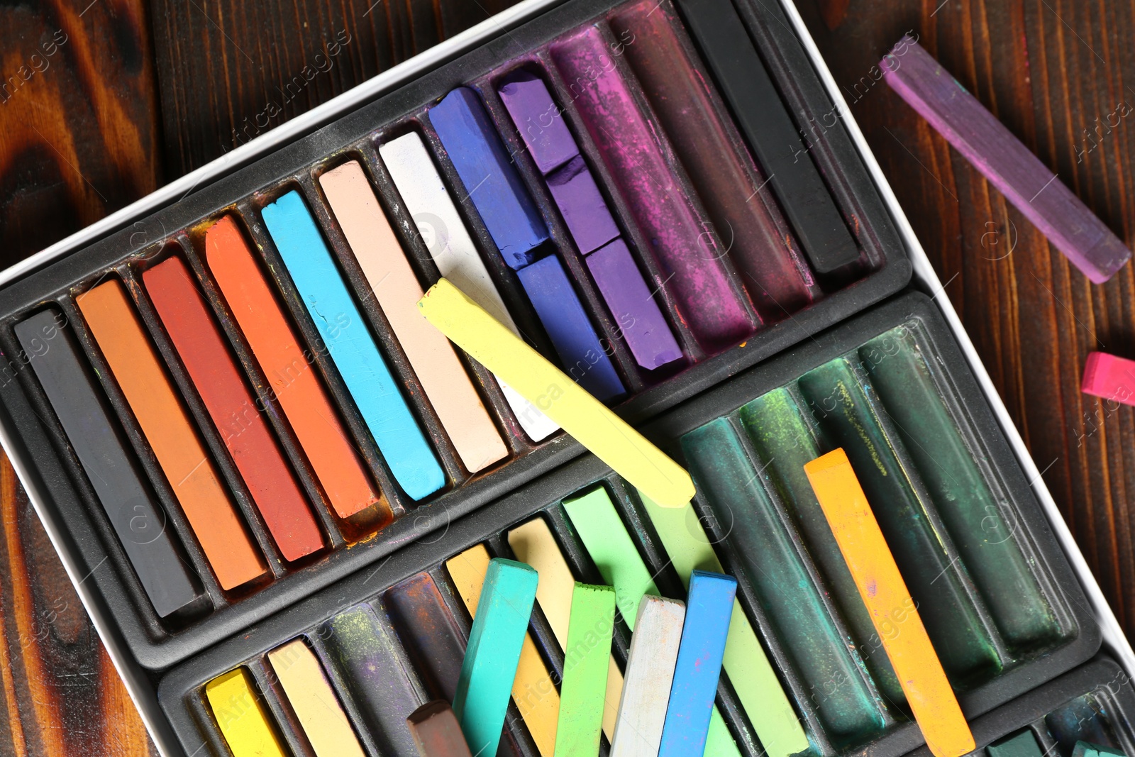 Set of colorful chalk pastels on wooden table, flat lay Photo of Set of colorful chalk pastels on wooden table, flat lay