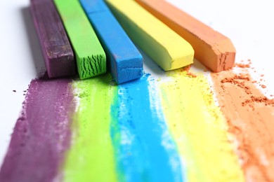 Photo of Colorful chalk pastels on white background, closeup