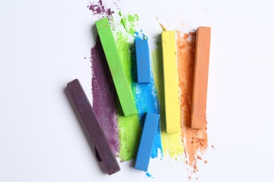Photo of Colorful chalk pastels on white background, flat lay