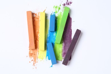 Photo of Colorful chalk pastels on white background, flat lay