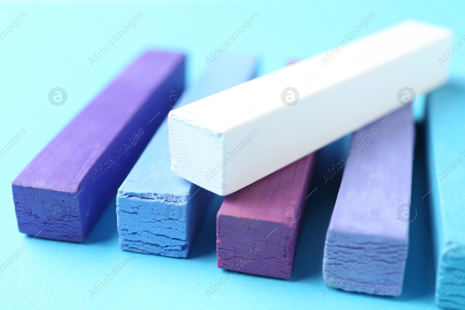 Colorful chalk pastels on light blue background, closeup Photo of Colorful chalk pastels on light blue background, closeup