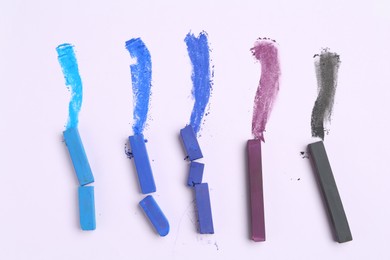 Photo of Colorful chalk pastels on white background, flat lay