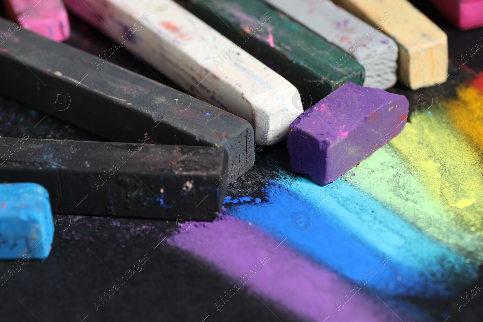 Colorful chalk pastels on black background, closeup Photo of Colorful chalk pastels on black background, closeup