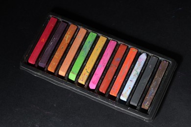 Photo of Set of colorful chalk pastels on black background