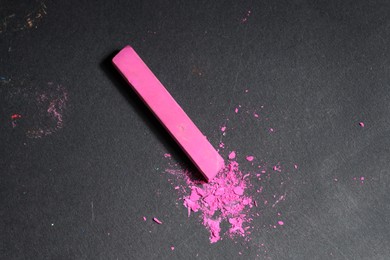 Photo of Pink chalk pastel on black table, top view. Space for text