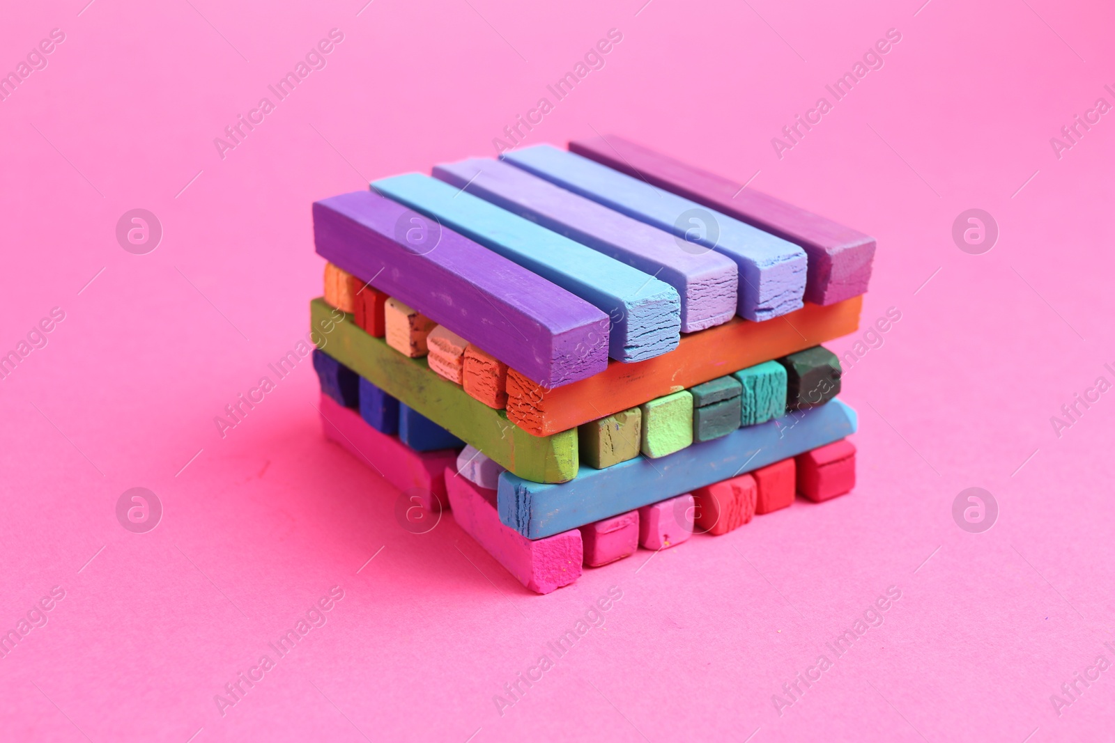 Many colorful chalk pastels on pink background, closeup Photo of Many colorful chalk pastels on pink background, closeup