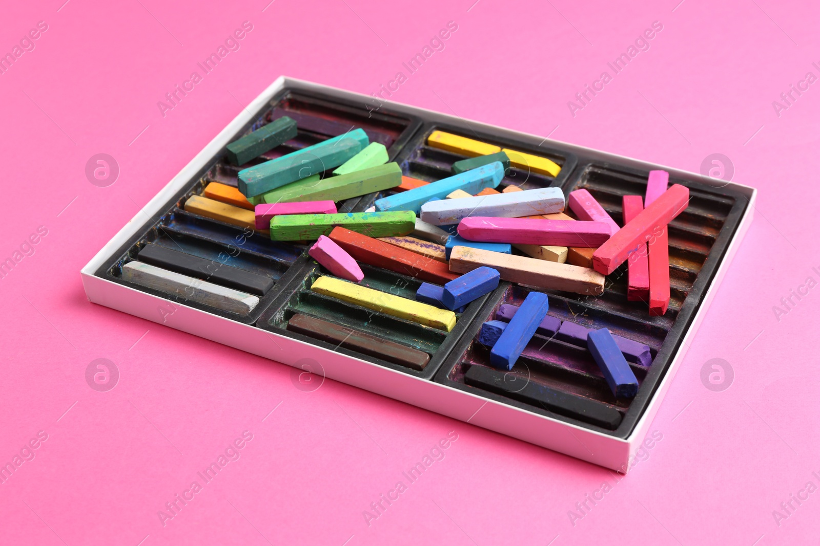 Set of colorful chalk pastels on pink background Photo of Set of colorful chalk pastels on pink background