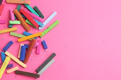 Photo of Many colorful chalk pastels on pink background, flat lay. Space for text