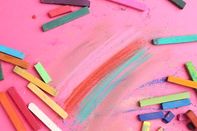 Photo of Many colorful chalk pastels on pink background, flat lay