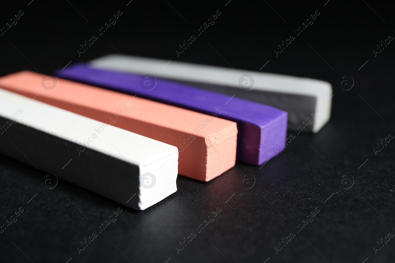 Many colorful chalk pastels on black background, closeup Photo of Many colorful chalk pastels on black background, closeup