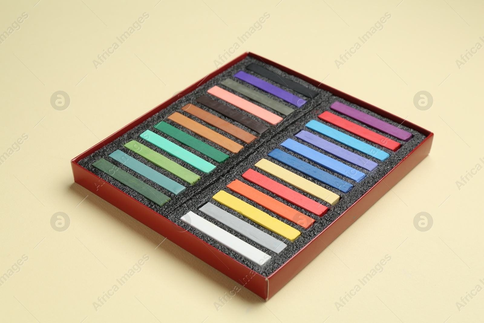 Set of colorful chalk pastels on beige background Photo of Set of colorful chalk pastels on beige background