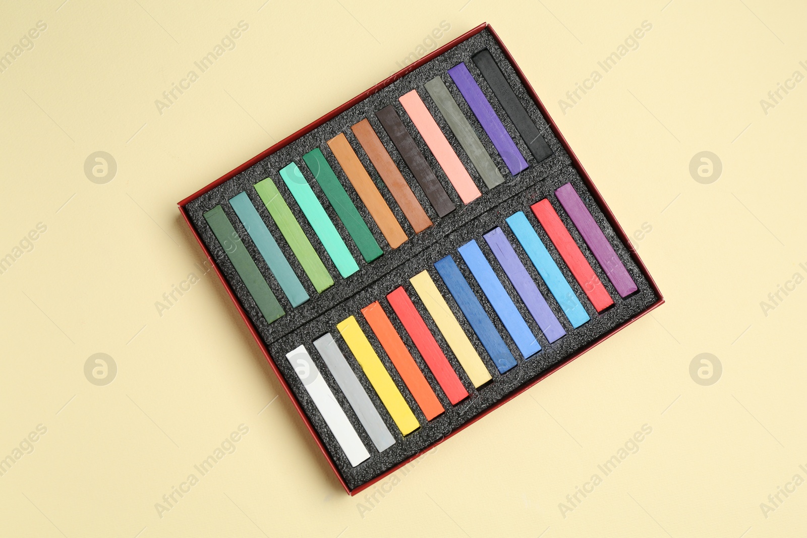 Set of colorful chalk pastels on beige background, top view Photo of Set of colorful chalk pastels on beige background, top view