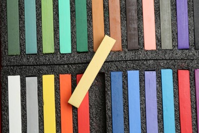 Photo of Set of colorful chalk pastels as background, closeup