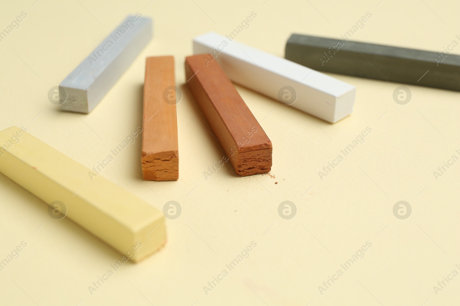 Many colorful chalk pastels on beige background, closeup Photo of Many colorful chalk pastels on beige background, closeup