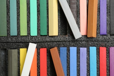 Photo of Set of colorful chalk pastels as background, closeup