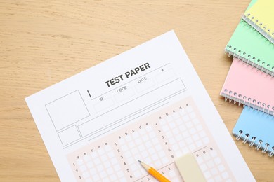Photo of Answer sheet, eraser, pencil and notebooks on wooden table, flat lay. Student passing exam
