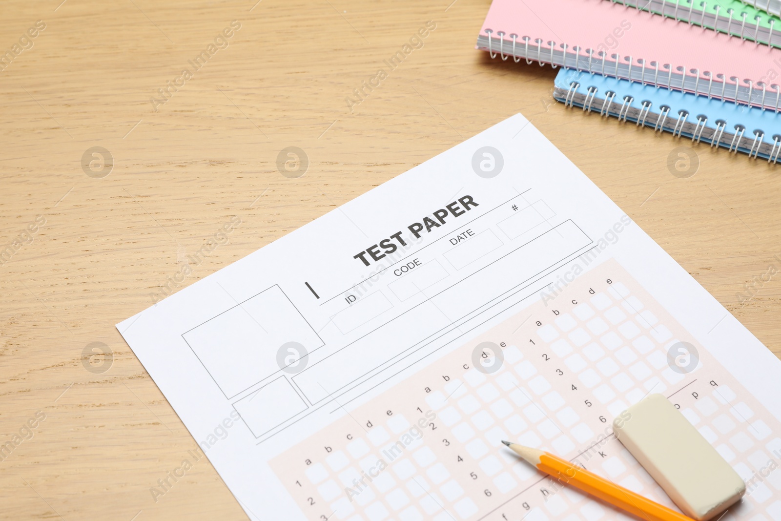 Answer sheet, eraser, pencil and notebooks on wooden table, closeup. Student passing exam Photo of Answer sheet, eraser, pencil and notebooks on wooden table, closeup. Student passing exam