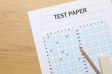 Photo of Answer sheet, eraser and pencil on wooden table, flat lay. Student passing exam