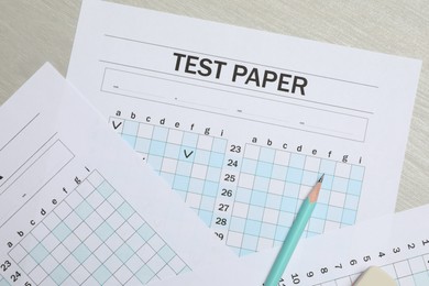 Photo of Answer sheets and pencil on wooden table, flat lay. Student passing exam