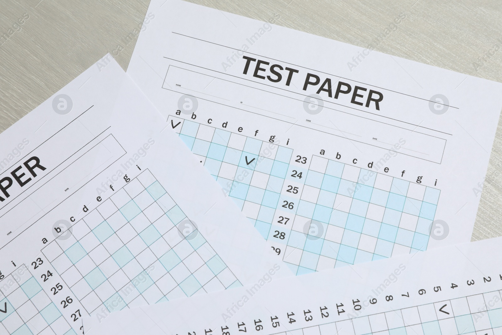 Photo of Answer sheets on wooden table, flat lay. Student passing exam